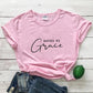 Casual women's graphic tee featuring the Saved by Grace slogan in cursive and capitals