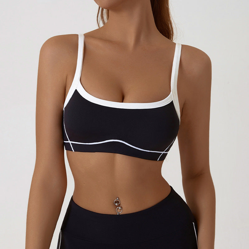 Two tone womens activewear set on a studio model with thin spaghetti straps crossing the back