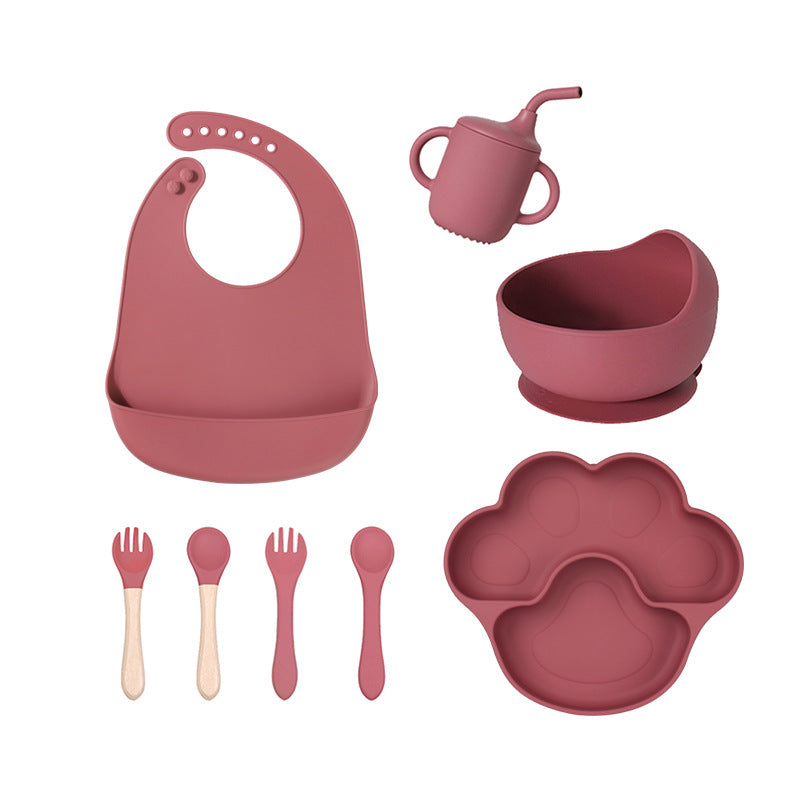 Burgundy 8-piece baby feeding set with a bib, a sippy cup, a bowl, four utensils and a bear paw plate