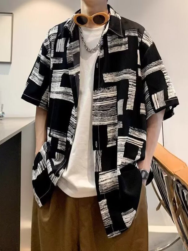 Black and white block print camp shirt worn open over a white tee, dropped shoulders