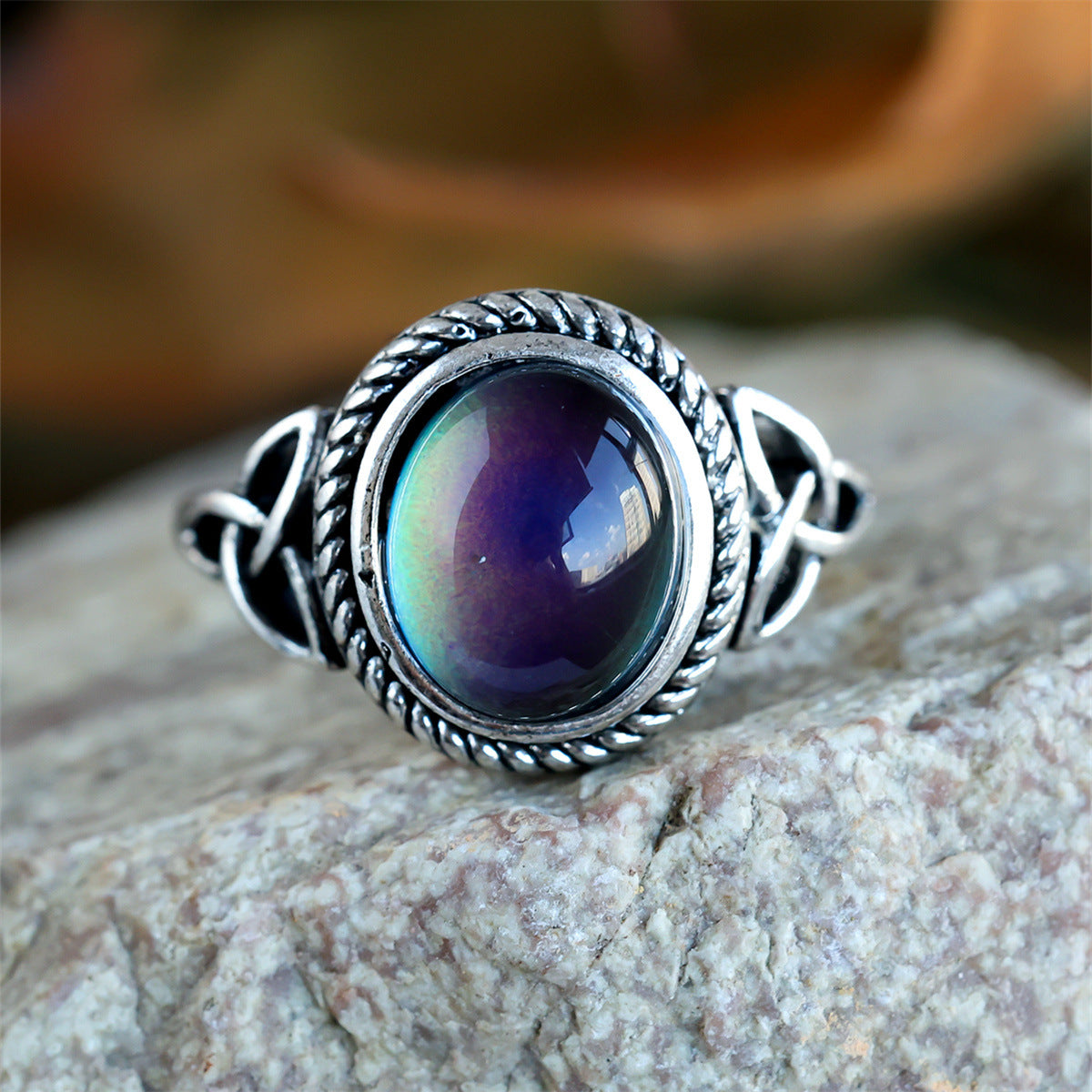Angled hero shot of the silver tone Celtic knot ring with a glossy mood stone