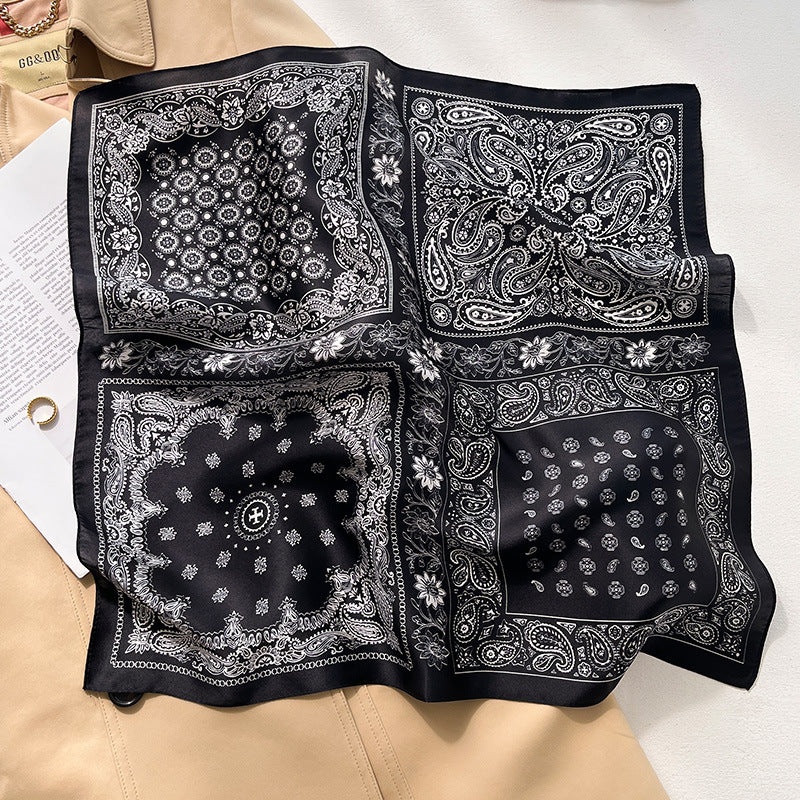 Black and white paisley bandana printed square scarf with a satin sheen and hemmed edges, shown displayed