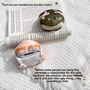 Olive resin frog case with pink bows beside an open white and pink shell on a magazine