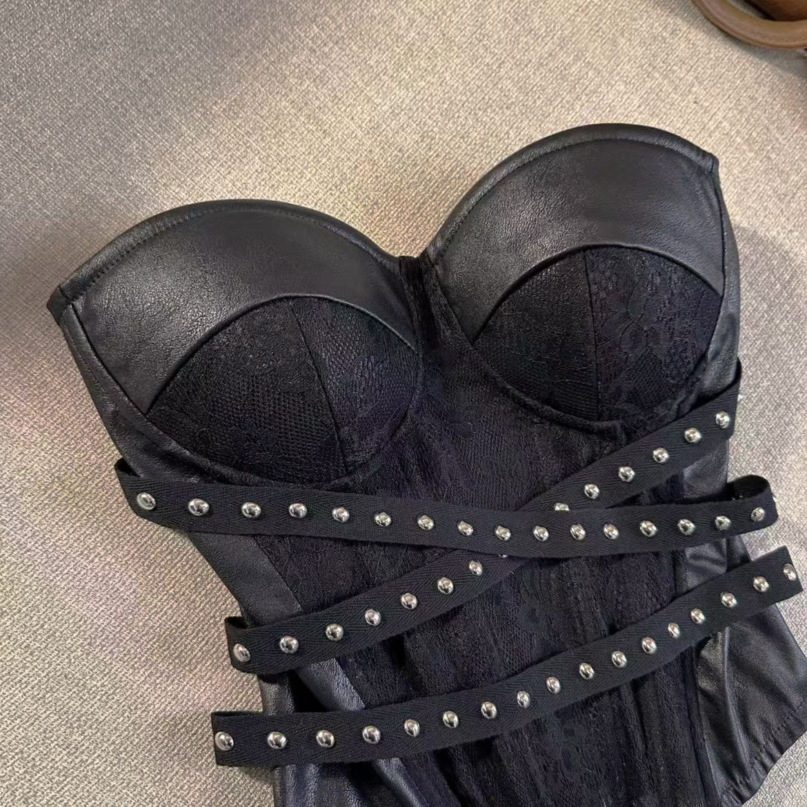 Angled view of the black bustier corset top showing molded cups and studded elastic crossover straps