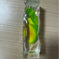 Clear squishy bar with green and yellow fruit wedges suspended inside on a desk