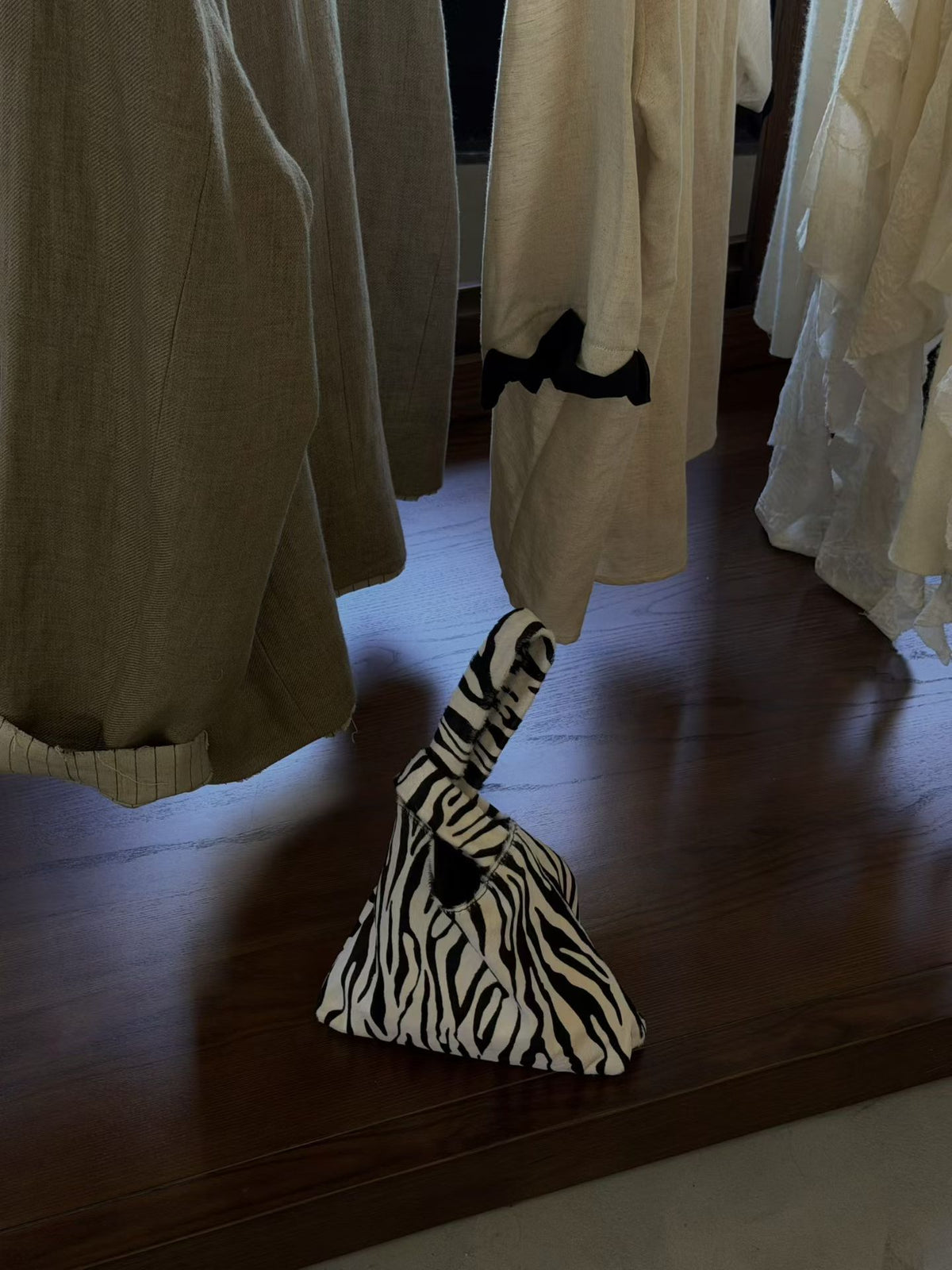 Zebra stripe triangle pouch bag with a looped handle on a dark wooden table, option Zebra Stripes