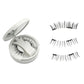 Round mirror compact open beside three natural style magnetic lash strips