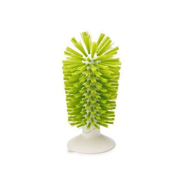 Green bristled glass cleaning brush standing upright on a white suction base