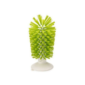 Green bristled glass cleaning brush standing upright on a white suction base