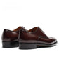 Rear view of a pair of brown cowhide derby shoes, stitched heel counters and low stacked block heels