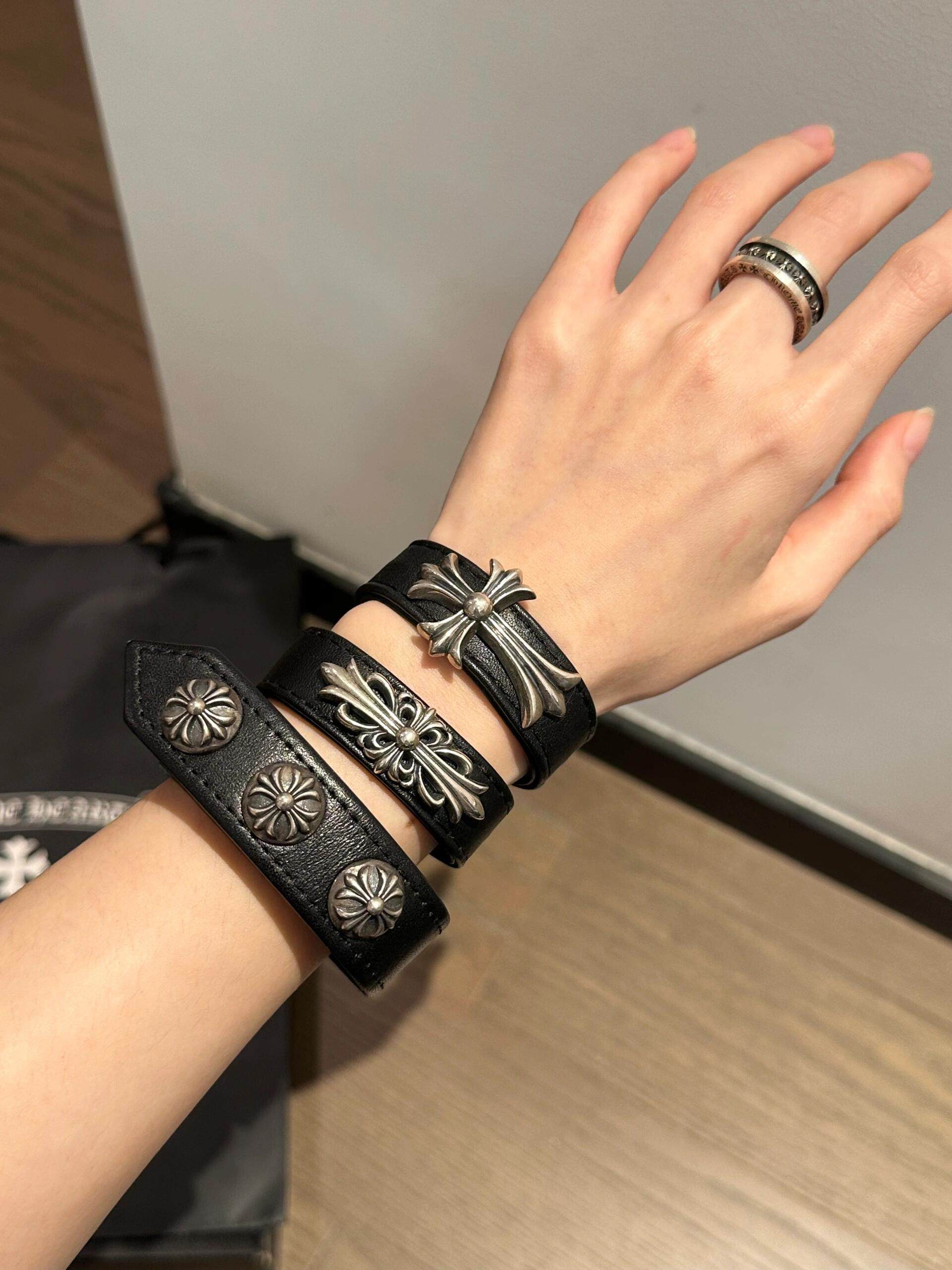 Black leather concho cuff bracelet styled with a casual outfit on the wrist