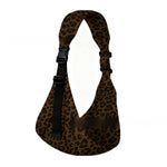 Parent wearing a brown leopard one-shoulder baby sling carrier with a toddler held close