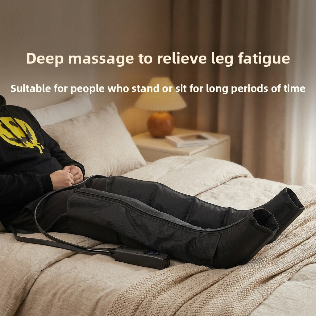 Black full leg air compression massage boots worn while resting on a bed with the wired handset alongside