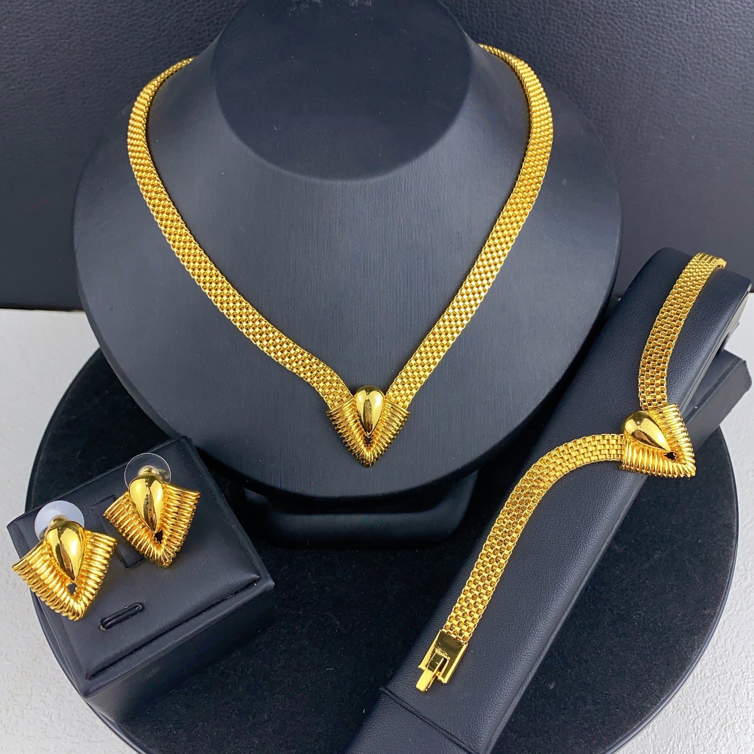 Imitation gold three-piece jewelry set shown in hand for scale, warm gold tone