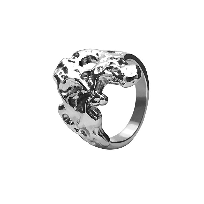 Stainless steel statement ring on white, molten relief face with pierced openings and a plain tapered band
