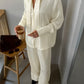 Close view of the buttercream crinkle shirt and wide leg trousers set with a slim self tie at the neck