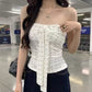 White strapless floral bow top from the front, long ribbon tails hanging past the hem