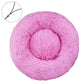 Pink round plush pet bed with a raised bolster rim on a plain background