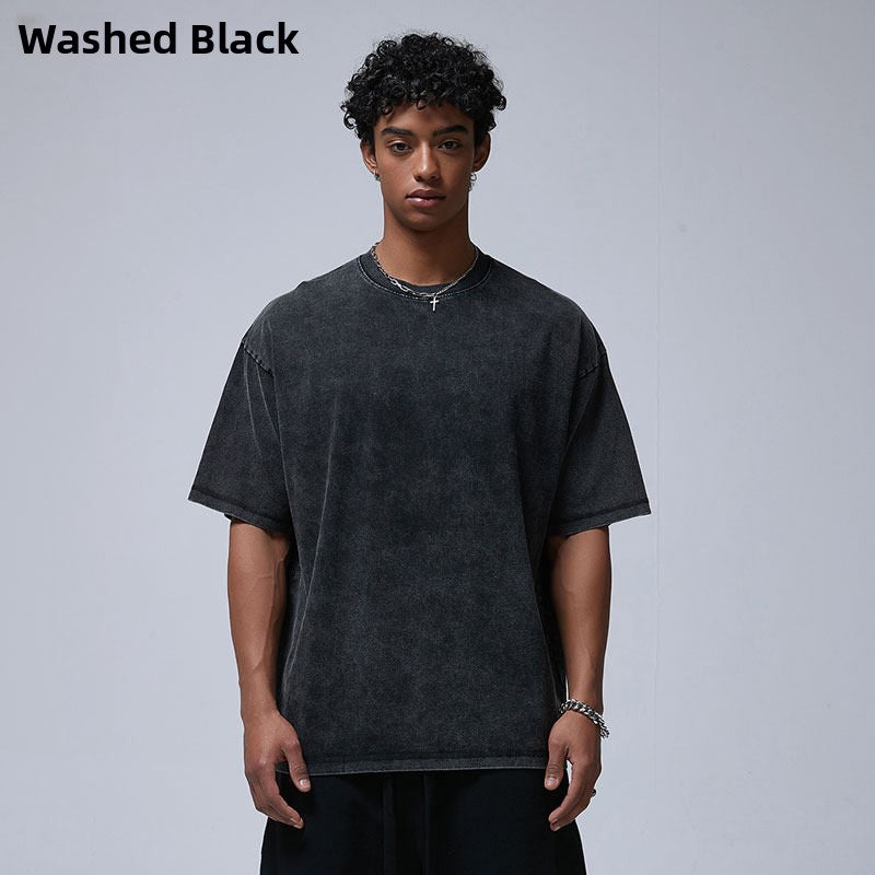 Man in a washed black loose cotton t-shirt with dropped shoulders, variant image for size M