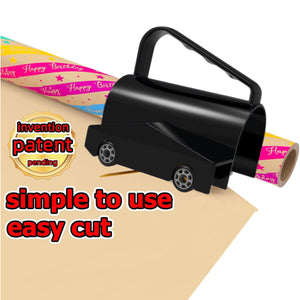 Black plastic roll cutter with an arched handle and wheels riding over a roll of birthday wrapping paper