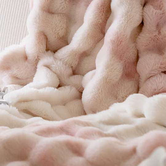 Plush ruched throw blanket in soft polyester fleece draped over a sofa, bubble texture