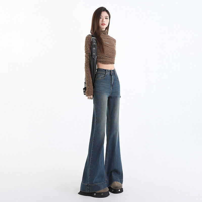 Walking shot of flared denim trousers brushing the top of brown boots