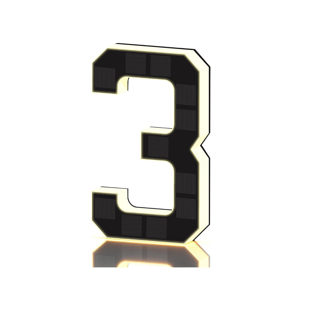 Black and gold solar LED house number sign, one character with a backlit warm outline, angled view