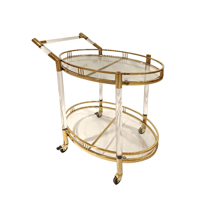 Two tier gold serving cart holding bottles and glasses styled as a drinks station