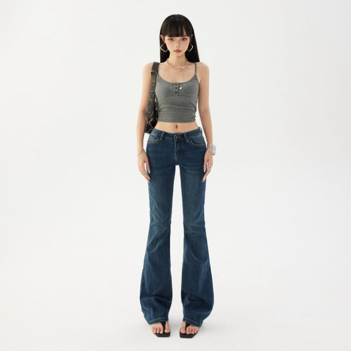 Low rise vintage wash flared jeans on a model, front view styled with a shoulder bag and sandals