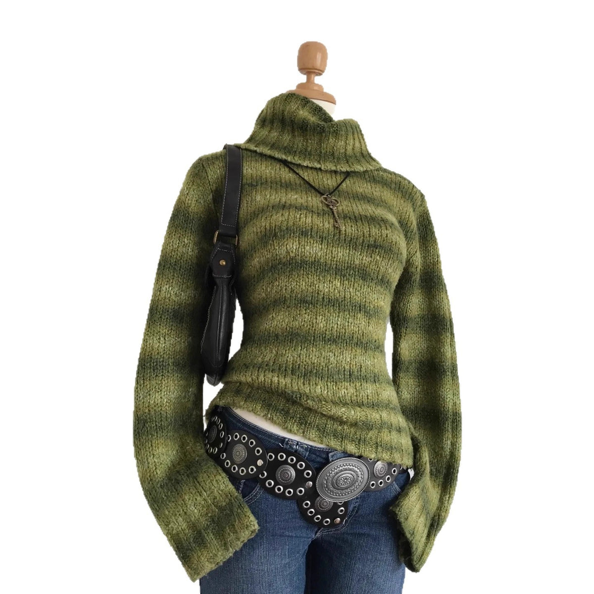 Green striped knit sweater with high collar on a mannequin against a white background, bag and belt for styling