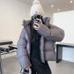 Short boxy down puffer jacket displayed flat with wide box quilting across the body