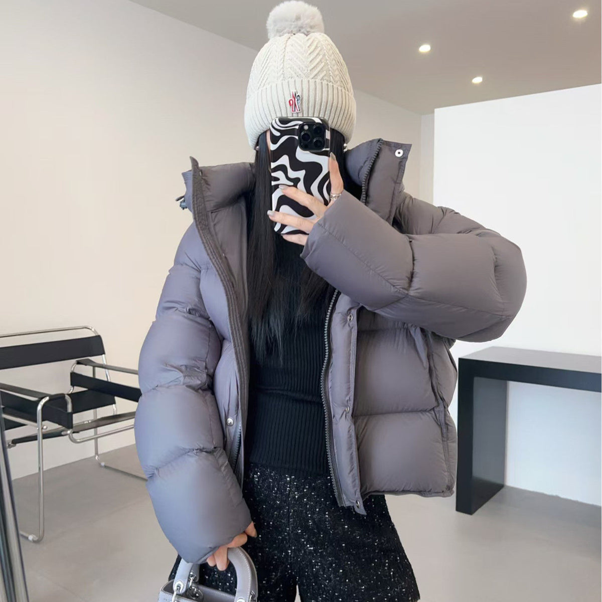 Short boxy down puffer jacket displayed flat with wide box quilting across the body