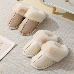 Beige and cream plush cuff mule slippers on a striped rug, each with a wide plush cuff