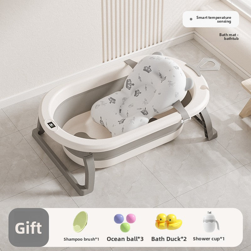 Baby bathtub with a white printed floating bath mat lying in the basin and a bath gift pack below