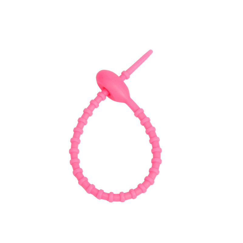 Flexible silicone cable tie shown open with the tail ready to thread through the head