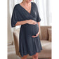 Expecting mother in a soft V neck maternity dress with relaxed dolman sleeves