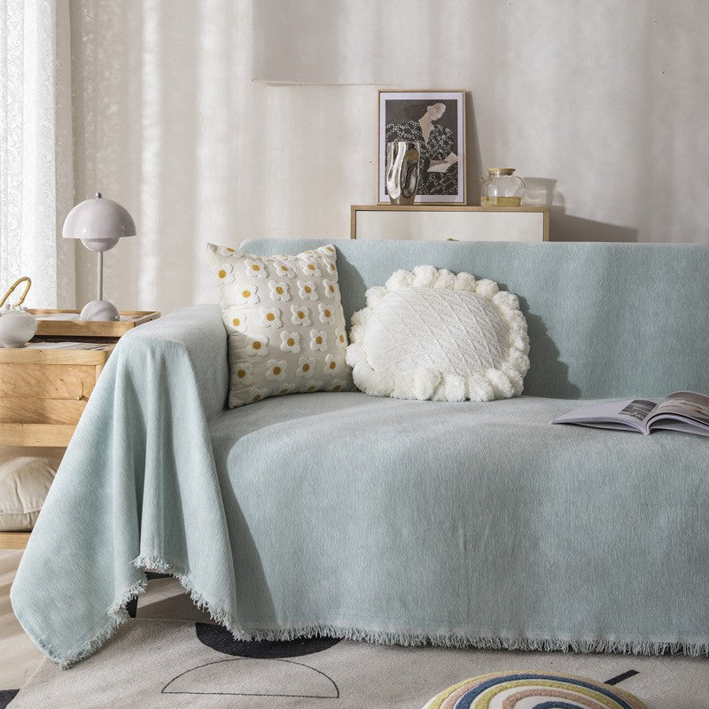 Angled view of the herringbone sofa cover draped across the seat cushions