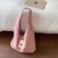 Front tie bow detail on a plaid canvas single strap shoulder bag