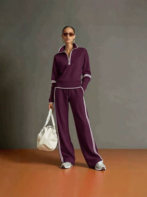 Purple half zip sweatshirt and wide leg pants set with white piping, worn full length