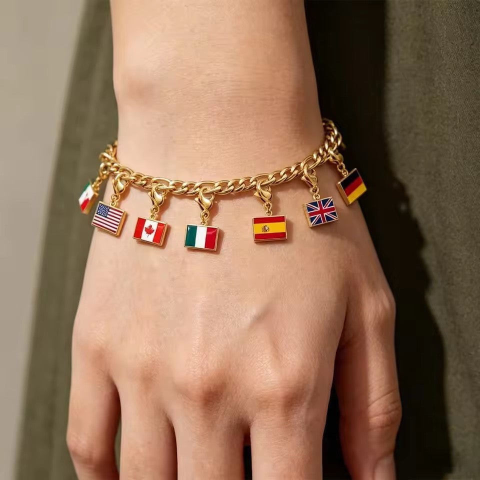 Gold flag charm bracelet on a wrist with several enamel country flag pendants