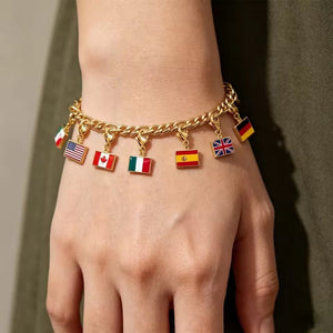 Gold flag charm bracelet on a wrist with several enamel country flag pendants