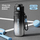 Silver ink gradient insulated 630ml spray and straw water bottle standing on a tennis court