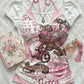 White printed halter tee shown with a rose card and perfume, pink neck ties visible