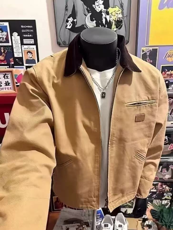 Khaki zip-up jacket with a dark brown collar on a mannequin, open front over a white tee and chain
