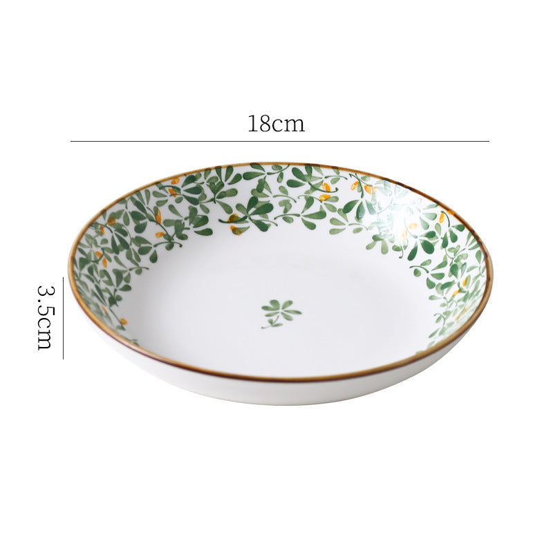 Green leaf porcelain soup spoon resting inside a matching bowl
