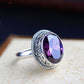 Purple stone statement ring worn on the hand as a bold evening accent on the finger