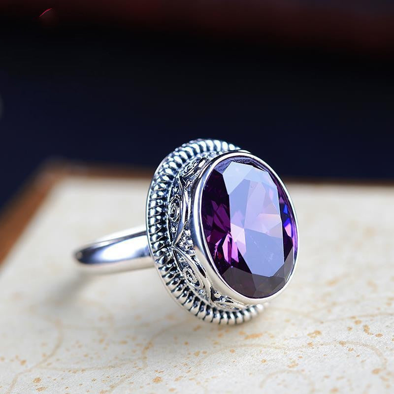 Purple stone statement ring worn on the hand as a bold evening accent on the finger