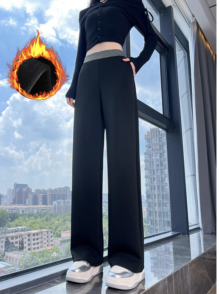 Woman in black high-waisted wide-leg pants with a gray waistband by a window, fleece lining graphic above