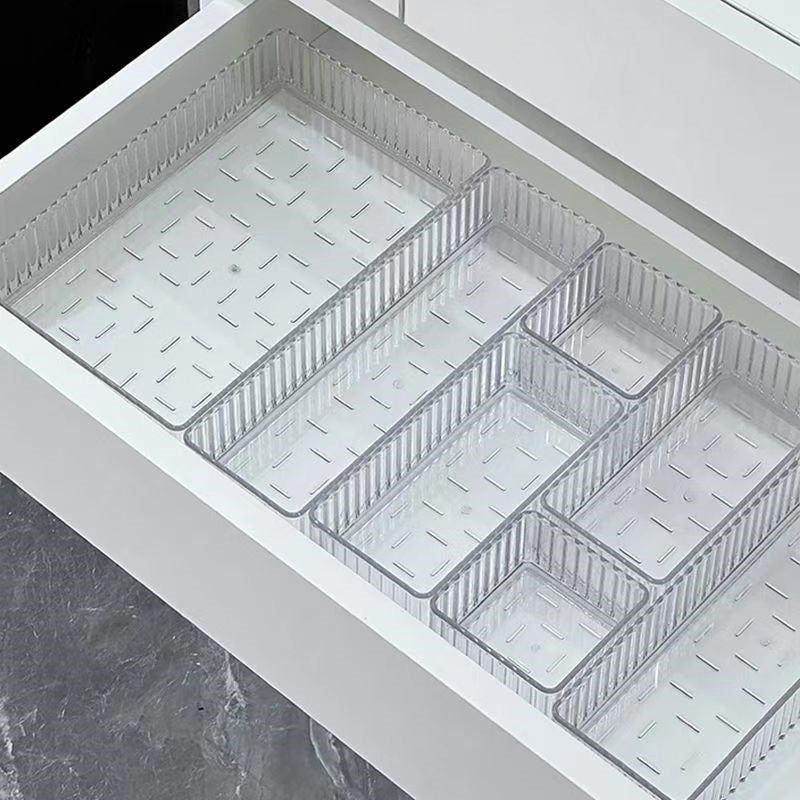 Clear acrylic drawer organizer trays sorting makeup and small bottles in a drawer