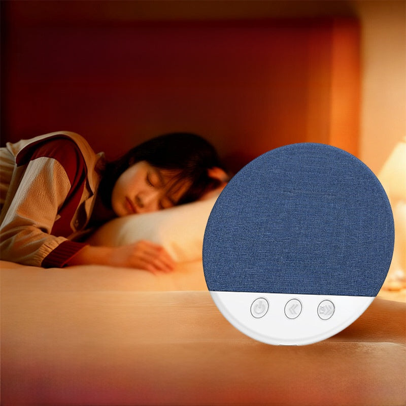 Blue sleep speaker on a nightstand with a sleeper resting in warm lamplight